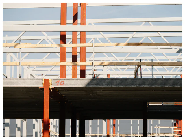 Multi-story building under construction showing structural steel beams and concrete floor slab.