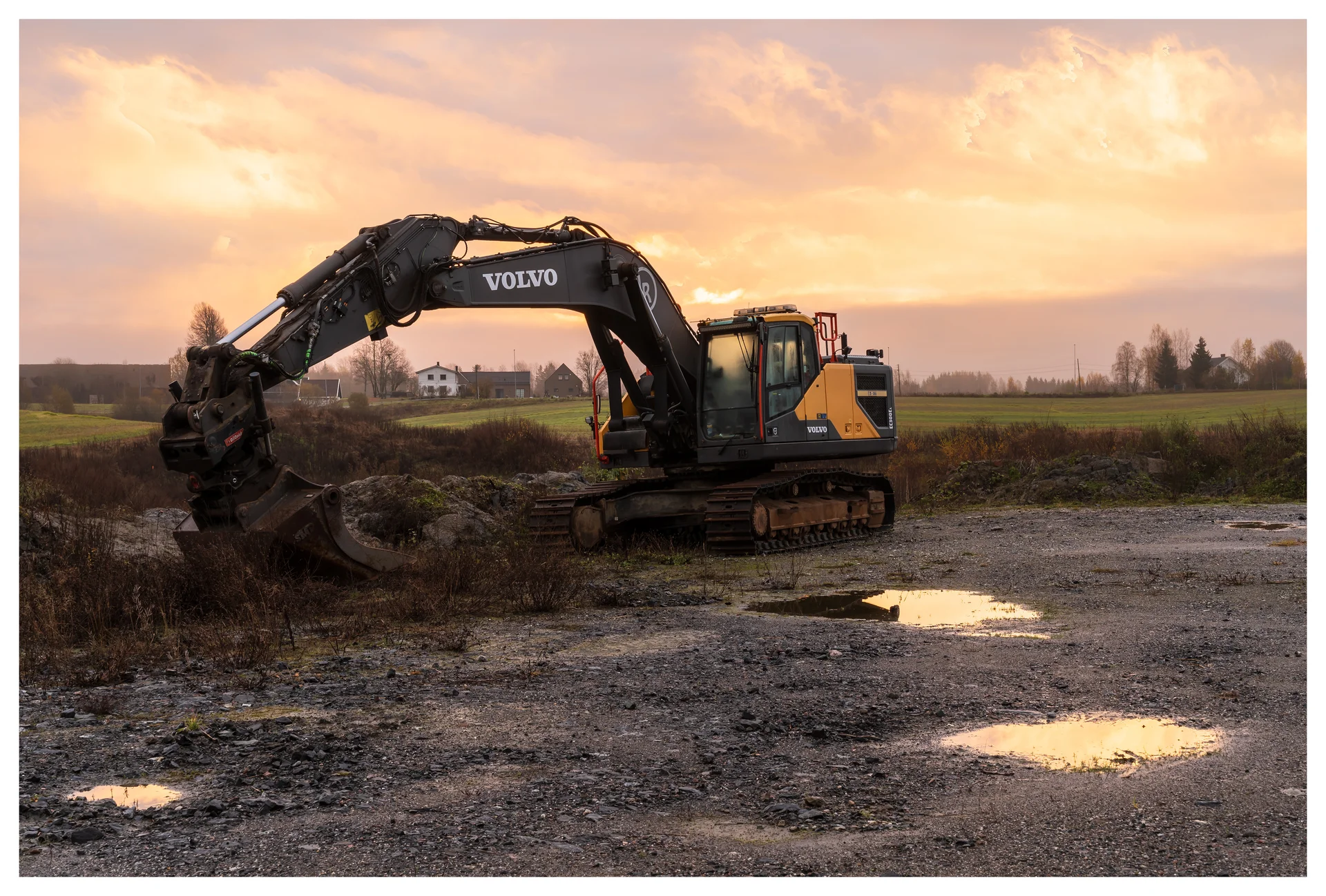 An excavator standing idle on a foggy Sunday morning — a quiet industrial scene before work begins.