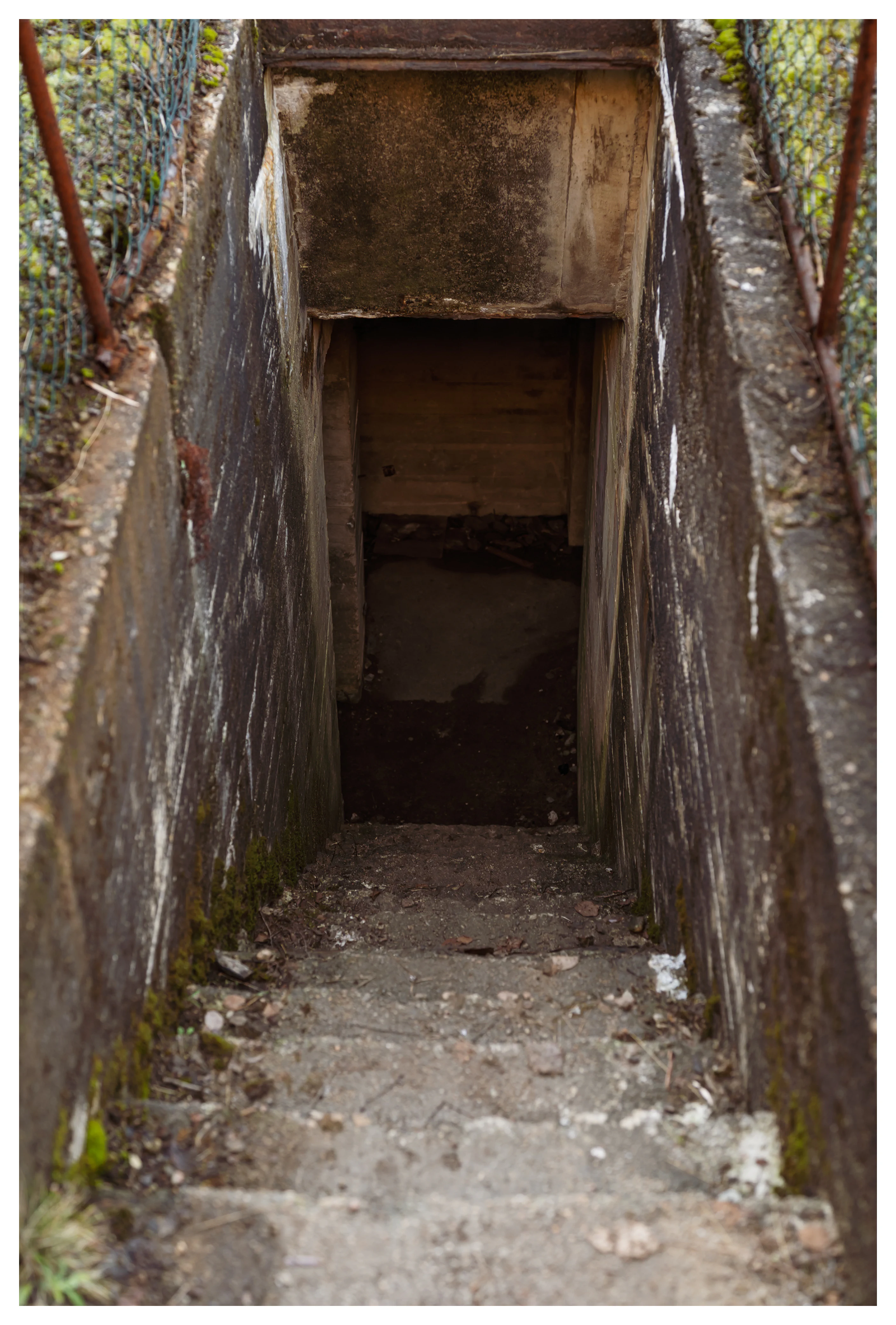 Narrow concrete staircase leading down into an underground tunnel at Hausvikodden Fort, showing part of the interior network beneath the coastal defenses.
