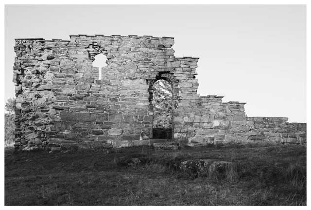 Black-and-white photograph of the medieval ruins of Margareta Church in Maridalen, Oslo, showing weathered stone walls and an arched opening.