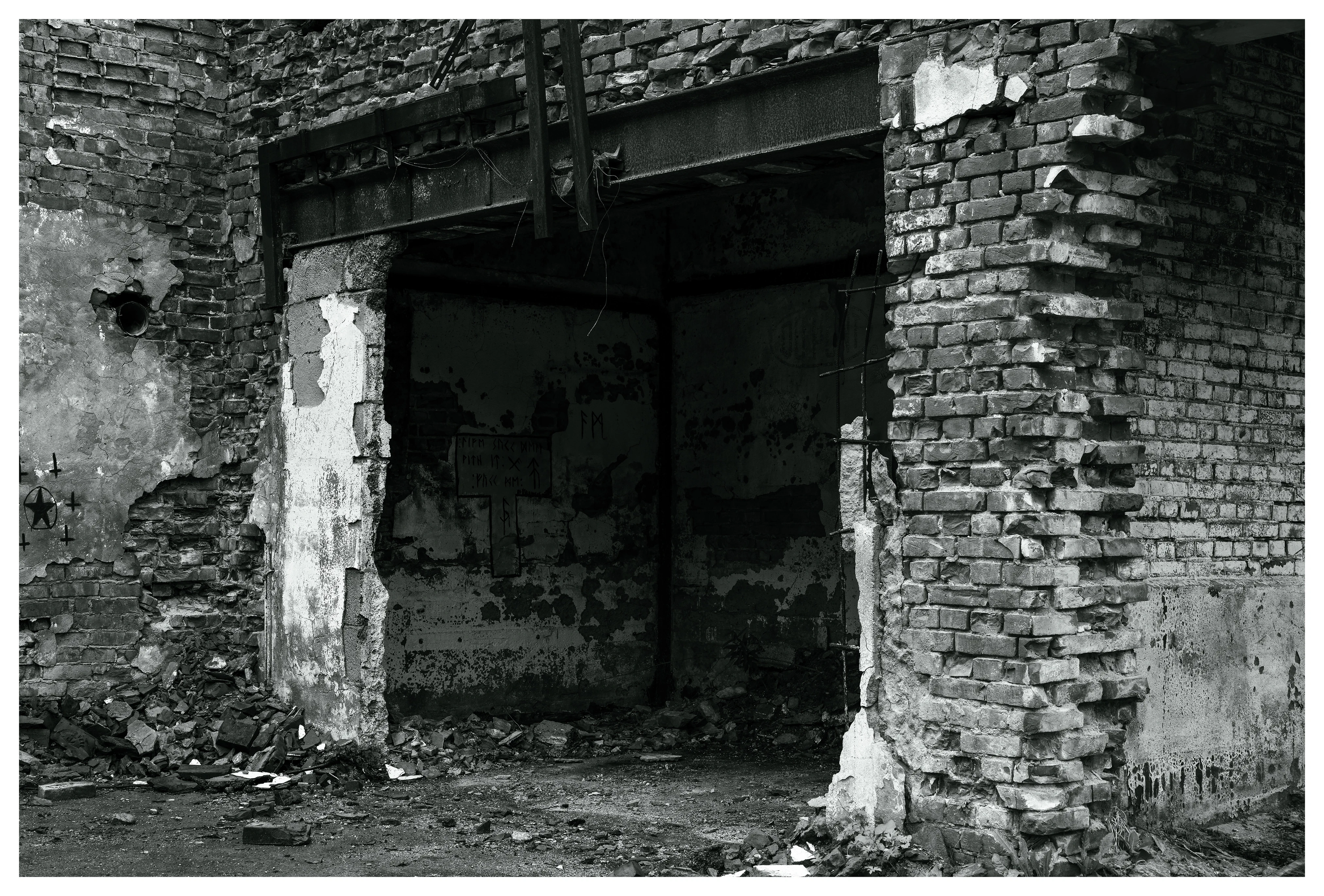 Crumbling brick entrance inside the abandoned Mago C power plant in Eidsvoll, showing damaged walls, exposed structure, and debris scattered across the floor.