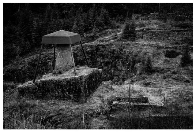 The preserved blast furnace structure at Feiring Ironworks, an old iron production site surrounded by forested hills